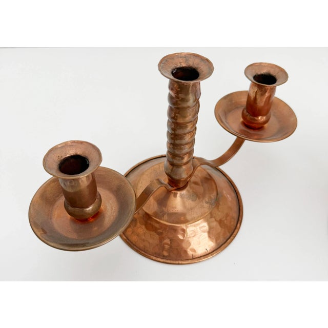 A warm and rustic pair of hammered and lightly aged copper candle holders with barley twist center stem and graceful...