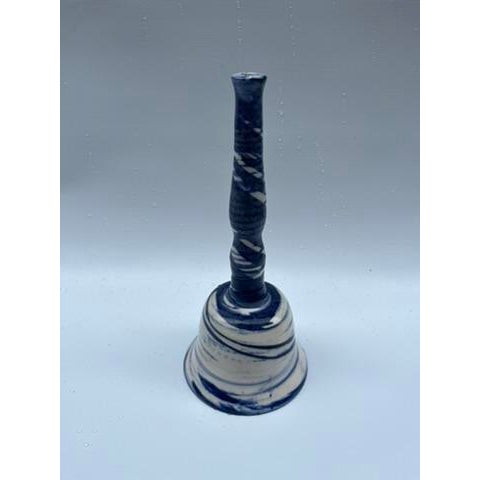 A single vintage art pottery bell with handle featuring a swirled blue and white finish.