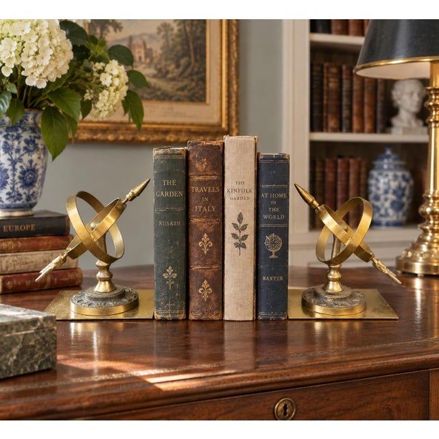 A handsome pair of circa 1980s cast brass bookends modeled as miniature celestial armillary sundials. Intersecting brass...