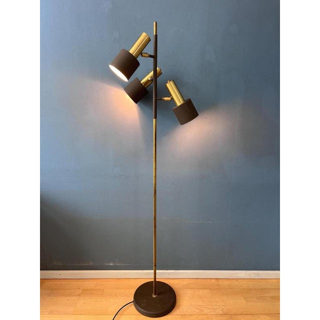 A beautiful vintage dijkstra floor lamp featuring a distinctive brass-colored metal frame with three brown shades and a...