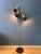 A beautiful vintage dijkstra floor lamp featuring a distinctive brass-colored metal frame with three brown shades and a...