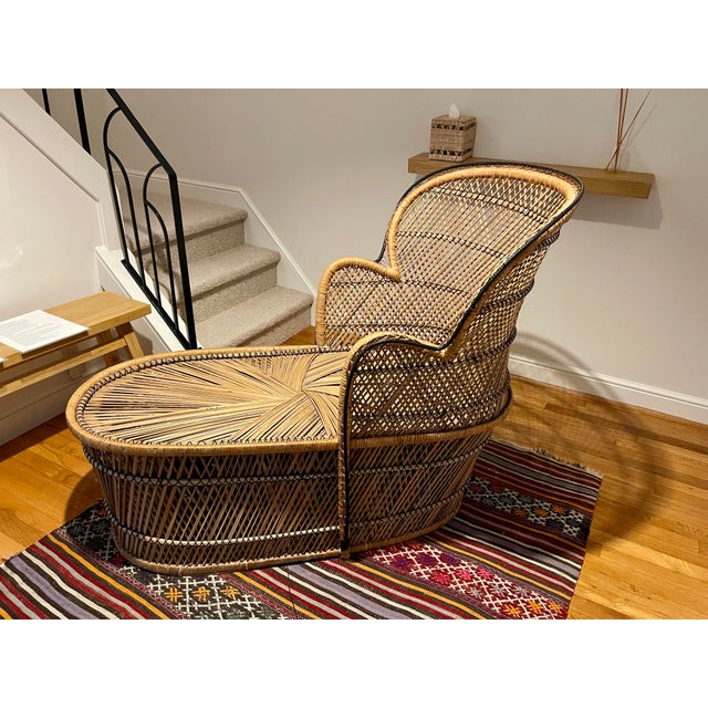 Gorgeous 1970s vintage peacock rattan chaise lounge chair with a very faint black woven accent around the perimeter....