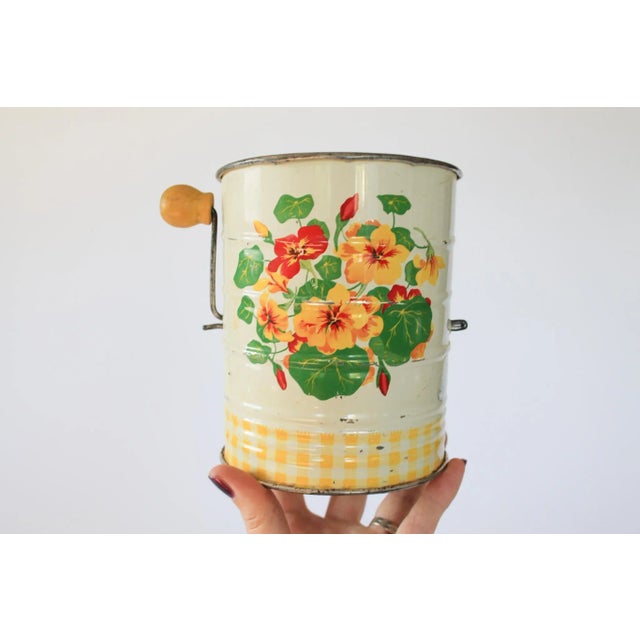 Vintage flour sifter with wood handle and floral motif. No maker mark. Stamped with the number 39 on the side. Some age...