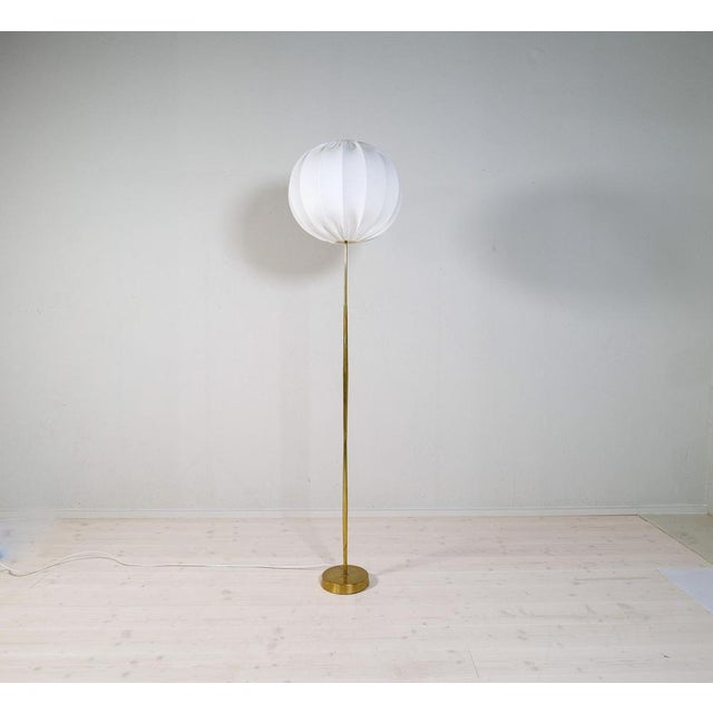 A gorgeous floor lamp made in brass with time glass shaped rod. Produced for asea this wonderful lamp was most likely...