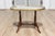 This exquisite early 20th-century French coffee table combines simple elegant design with timeless materials. The oval-...