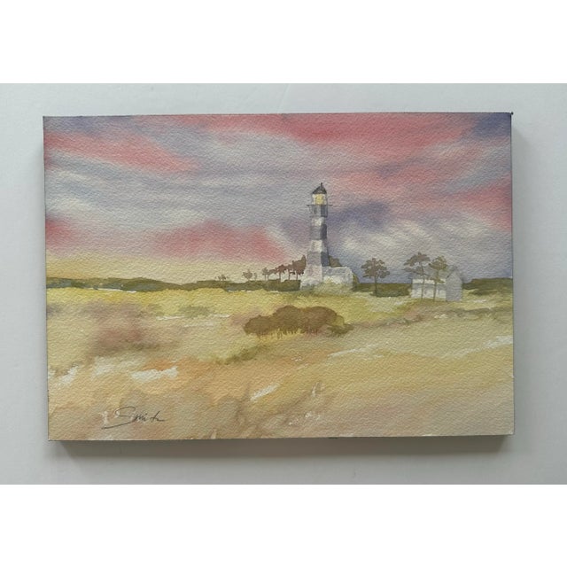 Watercolor Landscape featuring a lighthouse on the Outer Banks. This atmospheric watercolor painting depicts a peaceful...