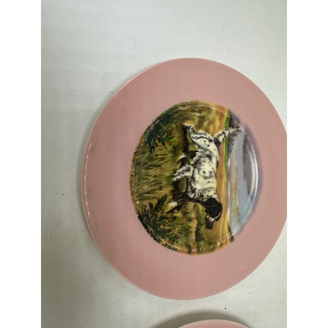 This is a pair of small decorative plates featuring sporting dog illustrations in the center, likely depicting English...