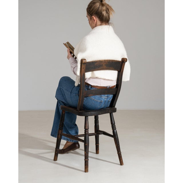 This dining chair makes its impression through dark aged wood, splat back. It was made in France during 1900s, a lineage...