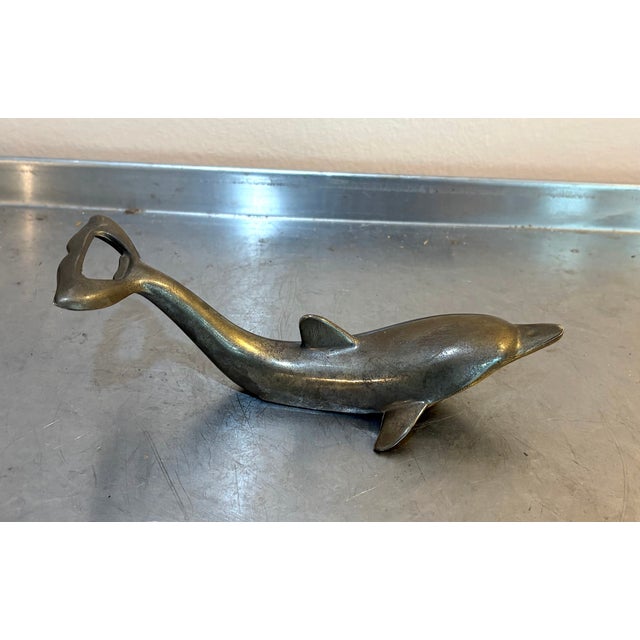 1960s-70s silver metal dolphin bottle opener. Some mild patina to metal throughout as shown but otherwise excellent...
