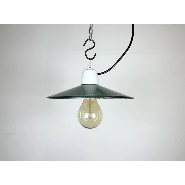 Vintage industrial enamel pendant lamp made in Poland during the 1970s. It features a green enamel shade with white enamel...
