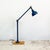 An articulated industrial lamp by dugdills, built from tubular steel and mounted on a wooden block base. The upright rises...