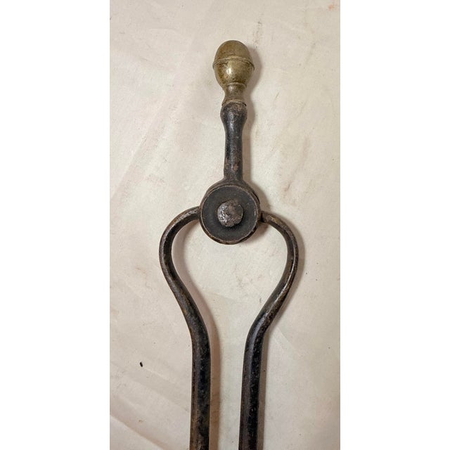 Up for sale is a pair of rare antique 18th century wrought iron and brass English fireplace tongs. The arms are wrought by...