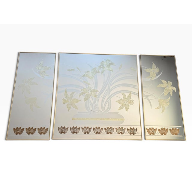 Striking vintage 1980s triptych mirror wall art featuring an elegant botanical composition of sweeping ivory foliage and...