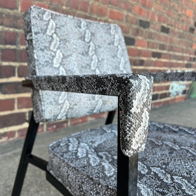 Recently reupholstered faux snake skin armchair with black metal base.