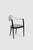 Set of four minimalist dining chairs defined by curved stainless steel backrests and two tone black metal frames. A...