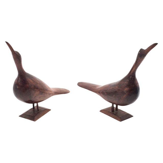 A sculptural duet of hand-carved shorebirds, their elongated forms rising with graceful lift as if caught mid-song along a...
