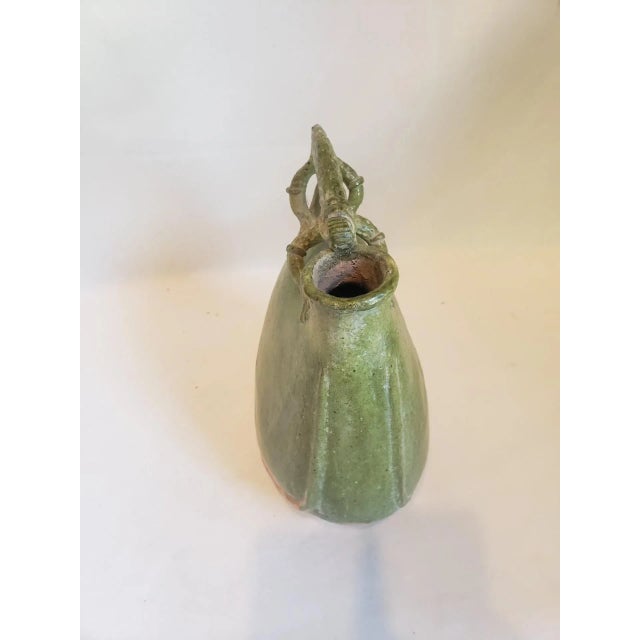Late 19th Century (c. 1875-1890) muted lime green oval shaped oil storage vessel with stylized animal figure handle.