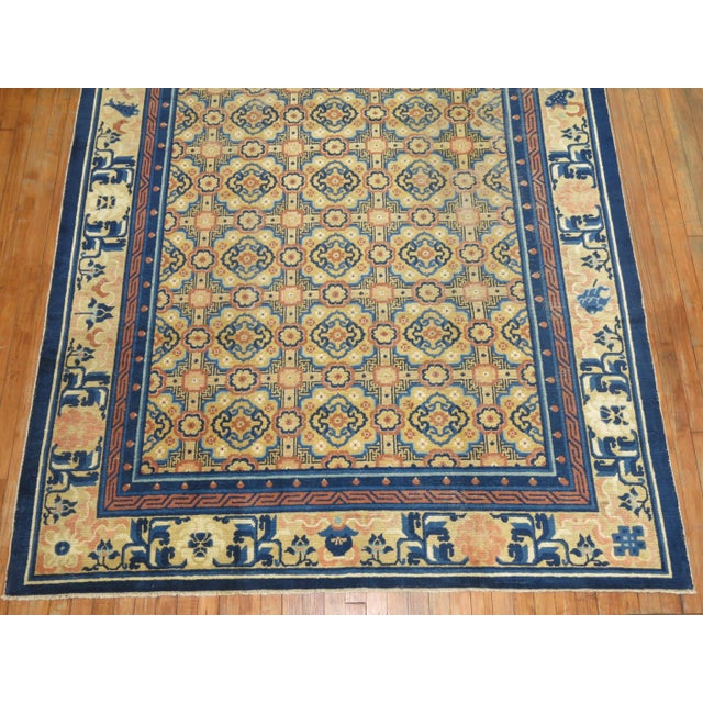 A charming early 20th century Chinese rug with an all over geometric motif in peach, beige, various shades of blue...