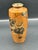 A beautifully hand painted Japanese ceramic vase featuring a warm persimmon toned ground with black and gold enamel...