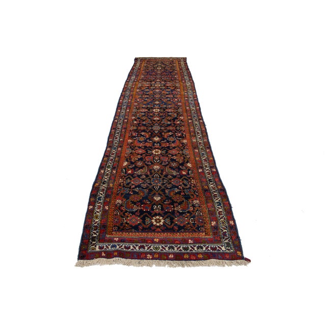 This handmade Persian Malayer wool rug dates back to the 20th century. It features a navy blue field with rust, yellow,...