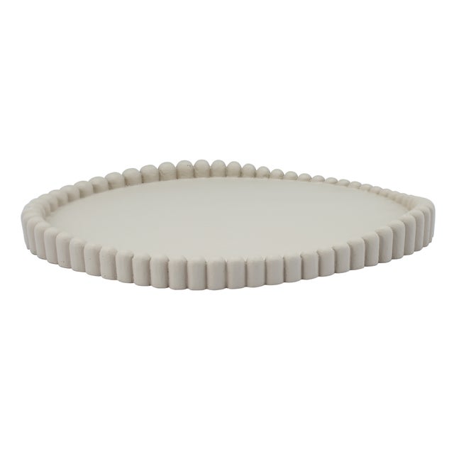 The Alna Catchall Tray channels a wabi-sabi aesthetic with organic curves, a sculptural beaded edge and modern texture,...