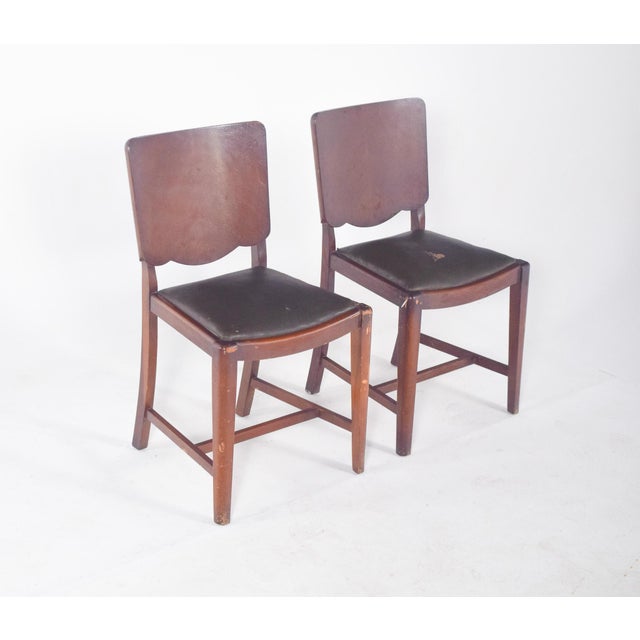 Pair of chairs upholstered in synthetic leather. The backrest has rounded lines and is slightly concave, offering comfort...