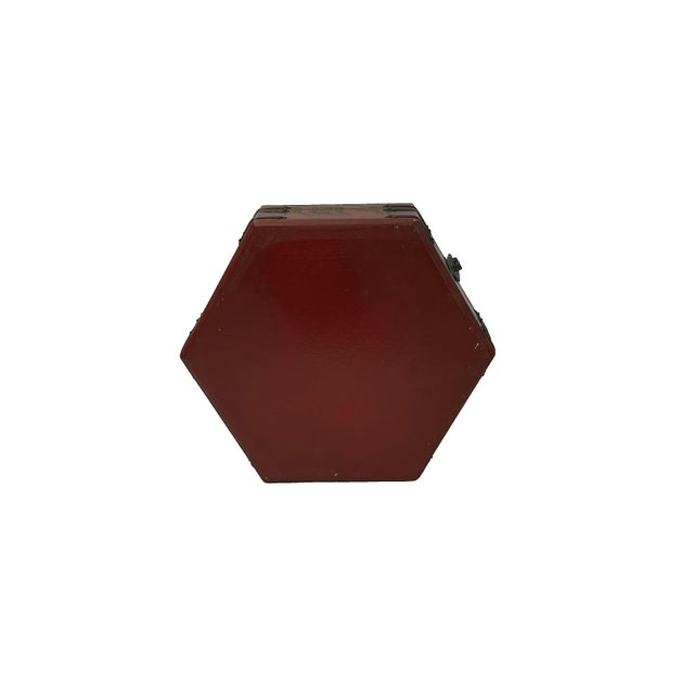 This striking hexagonal storage box is finished in a deep cinnabar-red lacquer, featuring a traditional landscape scene on...