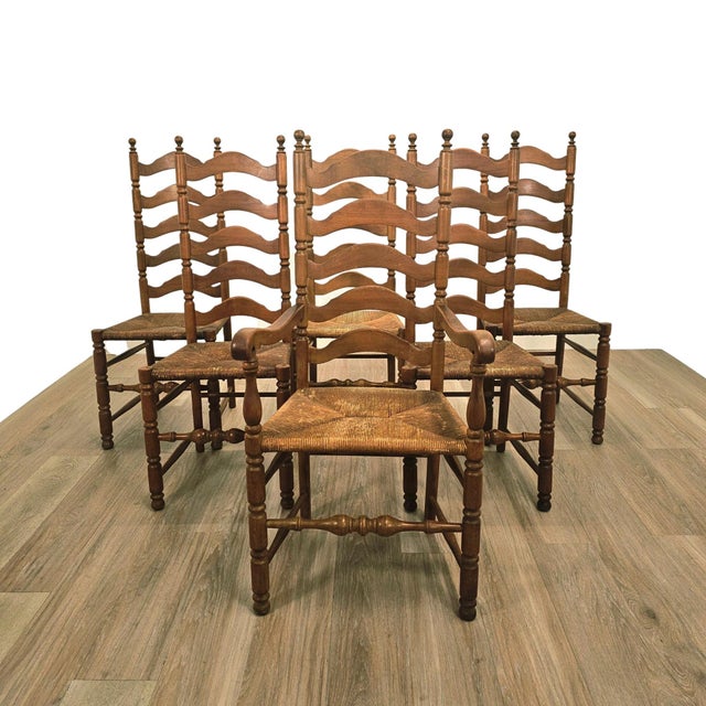 Set of six mid-century French Provincial ladderback dining chairs executed in solid wood with woven rush seats. This...