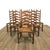 Set of six mid-century French Provincial ladderback dining chairs executed in solid wood with woven rush seats. This...