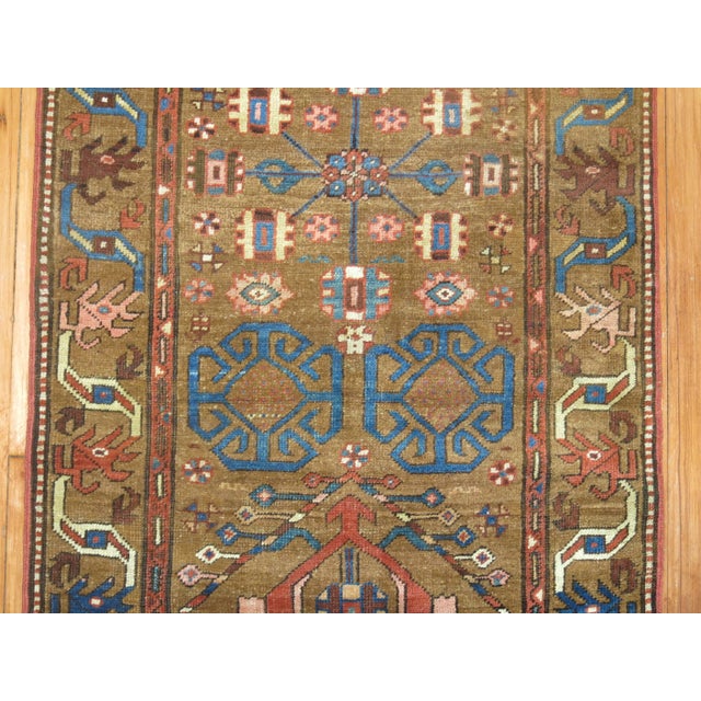 An early 20th century Tribal Persian Bakshaish runner in browns and blue. Measures: 2'9" x 13'8".