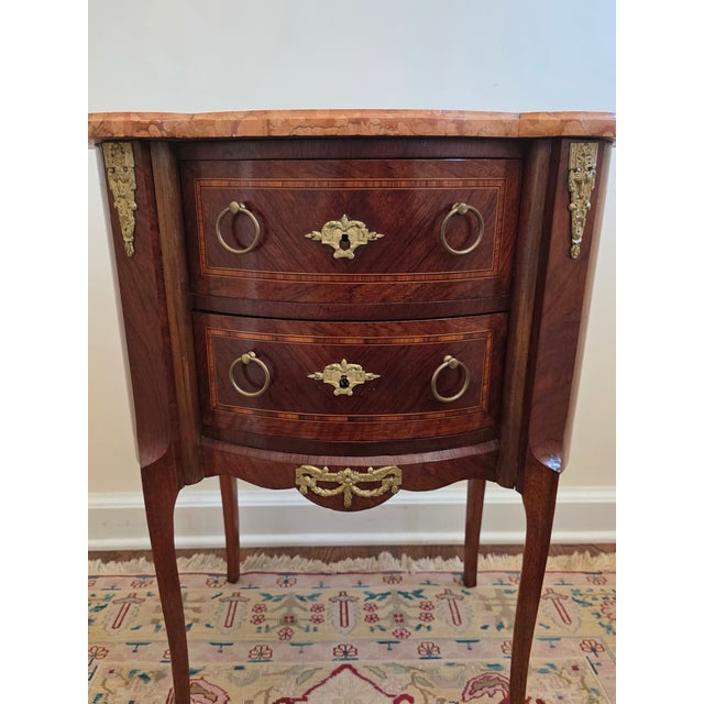 Antique French Louis XI style bedside night table or commode featuring a serpentine front and two drawers. Beautifully...