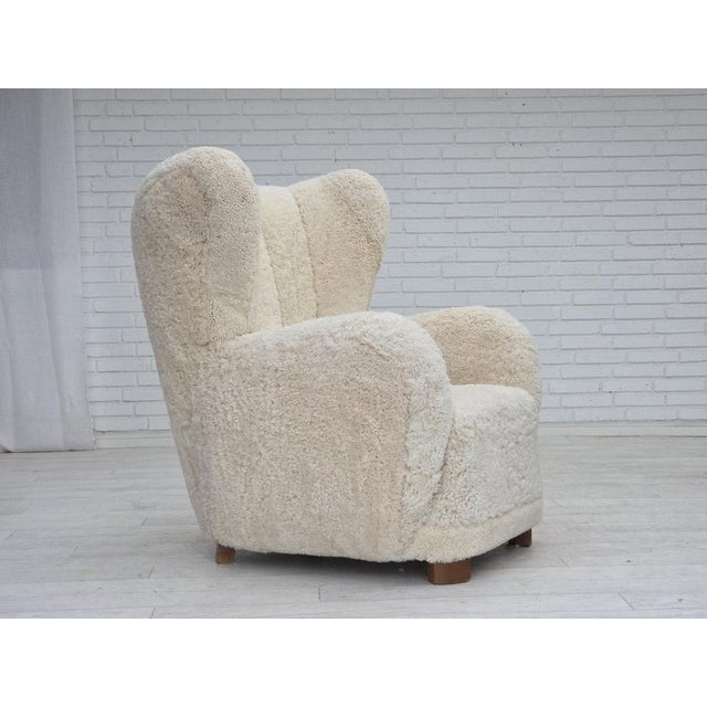 1960s, Danish design. Reupholstered high-backed armchair. Quality genuine sheepskin "Canberra" from Australia with quality...