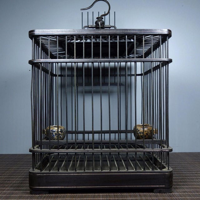 A beautifully crafted vintage Chinese birdcage made of dark wood (possibly ebony) with fine bronze wire bars. It features...