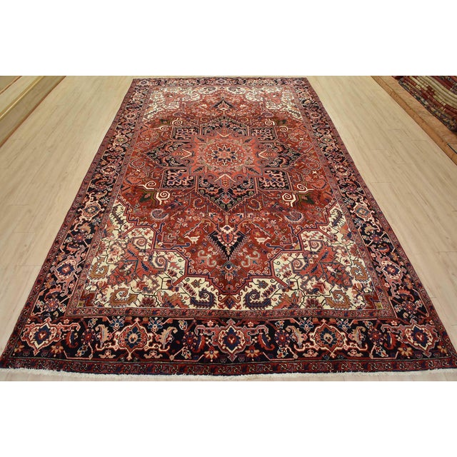 An authentic vintage traditional tribal Heriz rug hand-knotted with fine wool and natural dyes. This area rug features a...