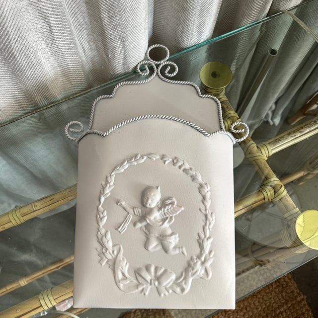 Vintage soft gray finish tole embossed classic motif of a cherub and wreath scalloped and roped design wall pocket,...