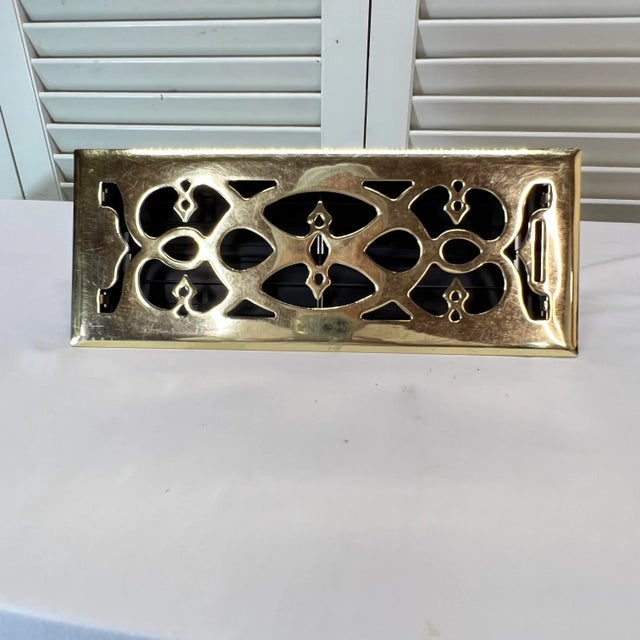 Vintage pierced brass heat/air cover. Brass cover measures 13.5” x 5.5” x 1.75”. Working vent box measures 11.75” x 3.75”...