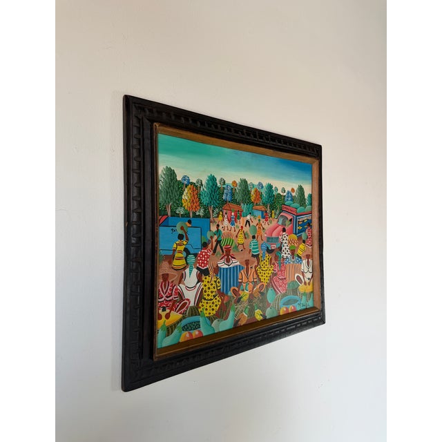 Charming M. Bazile Haitian folk art painting depicting a lively outdoor market scene filled with vibrant colors, figures,...