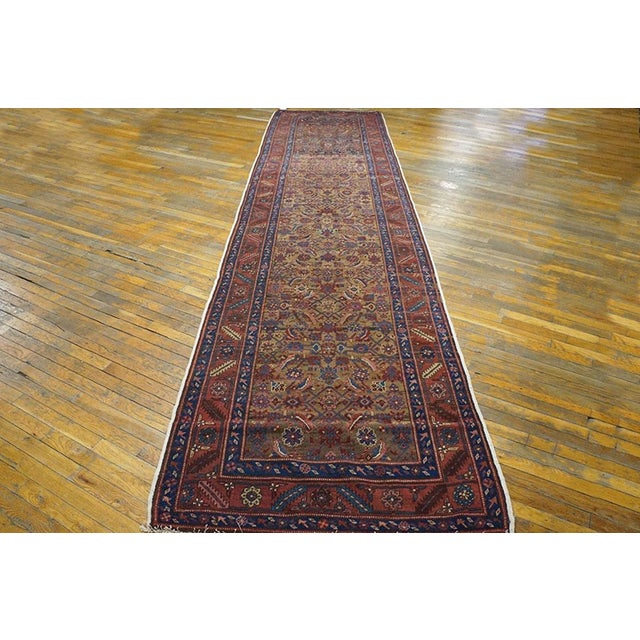 The camel-tone field is well-covered by a centralized allover Herati design detailed in royal blue, cream and madder red....