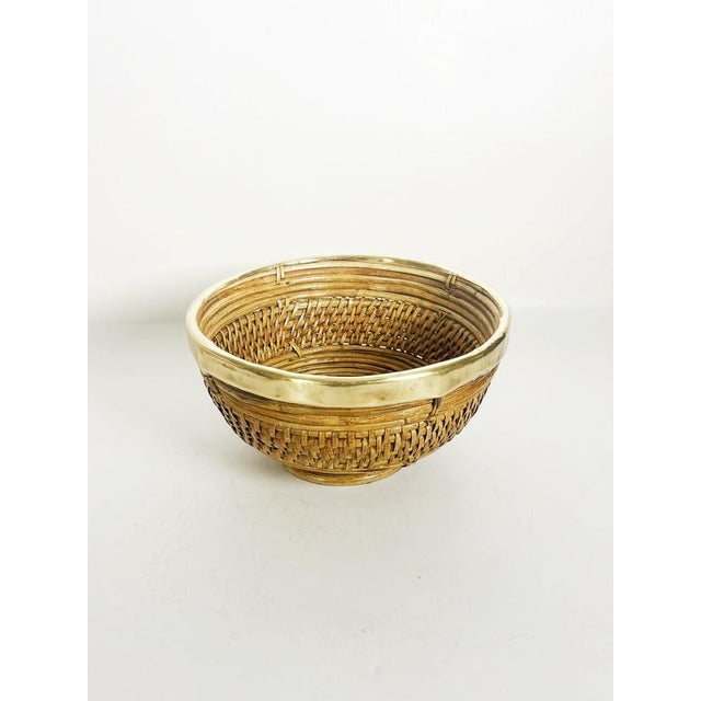 Elegant Italian bamboo and brass bowl dating from the 1960s, featuring a beautifully woven natural bamboo structure and a...