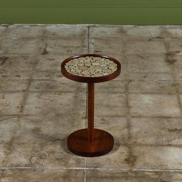 Round side table by Gordon & Jane Martz. The table top is inlaid with cement colored speckle glaze ceramic coin tiles,...