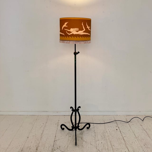 Elegant French floor lamp dating from the 1940s, crafted from wrought iron with a beautifully aged dark green and bronze...