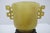 Chinese jade archaistic libation cup from the Qing dynasty, featuring geometric double handle designs. Carved from...