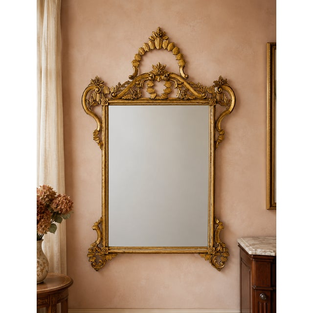 An authentic Italian giltwood wall mirror dating to 1975, retaining its original “Made in Italy” export label on the...