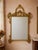 An authentic Italian giltwood wall mirror dating to 1975, retaining its original “Made in Italy” export label on the...