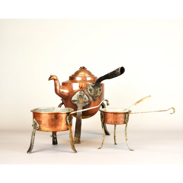 A set of copper dishes with metal legs. Two saucepans with a ladle and a small kettle with a capacity of 1 liter. diameter...