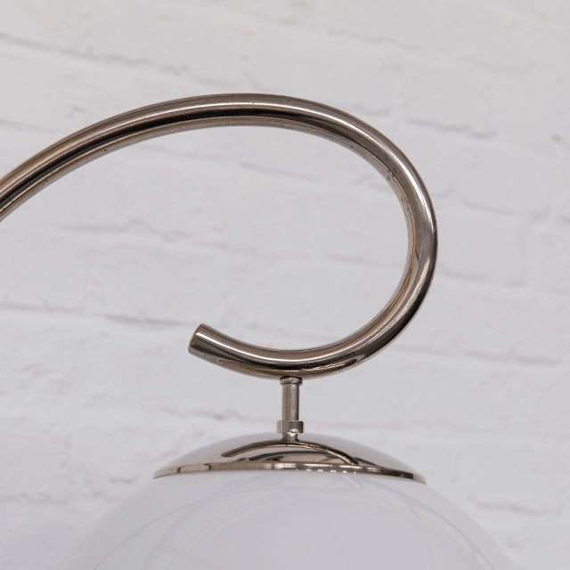 A floor lamp that captures the spirit of Streamline Modernism in one continuous motion – from the gently curved chrome-...