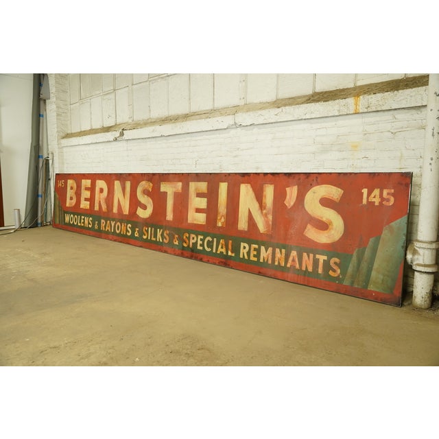 Reclaimed movie set sign made of aluminum in red, green, and white colors. The sign reads "145, Bernstein's, Woolens &...