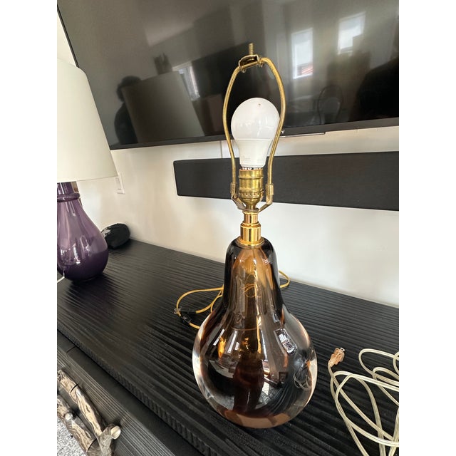 The Baker Furniture Amber & Clear Sommerso Glass Table Lamp is a hand-blown art glass piece crafted in Murano, Italy, for...