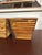 A pair of tapered square cachepots made of stacked bamboo reeds, laid horizontally around a wood frame, with the reed ends...