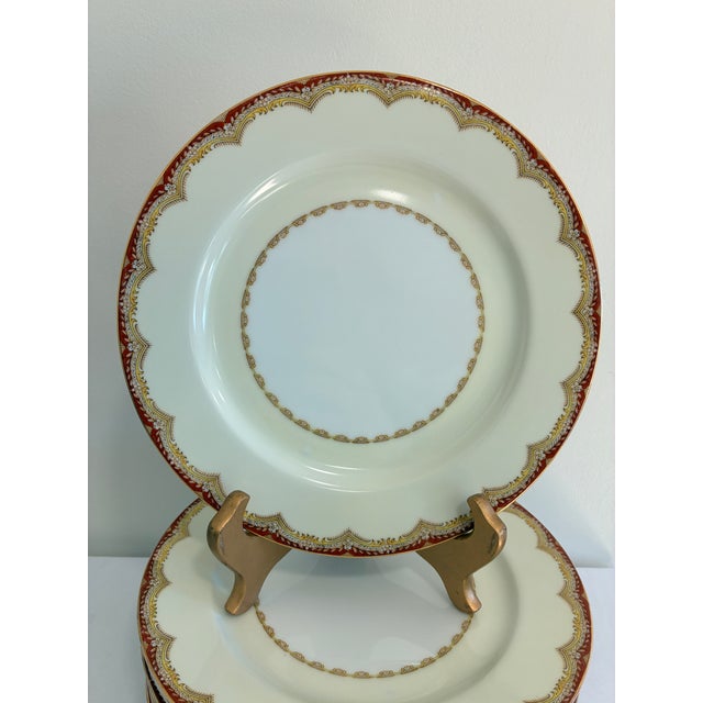 An elegant set of 12 Japanese Meito china dinner plates in the Celestine pattern. Creamy white centers are framed by a red...